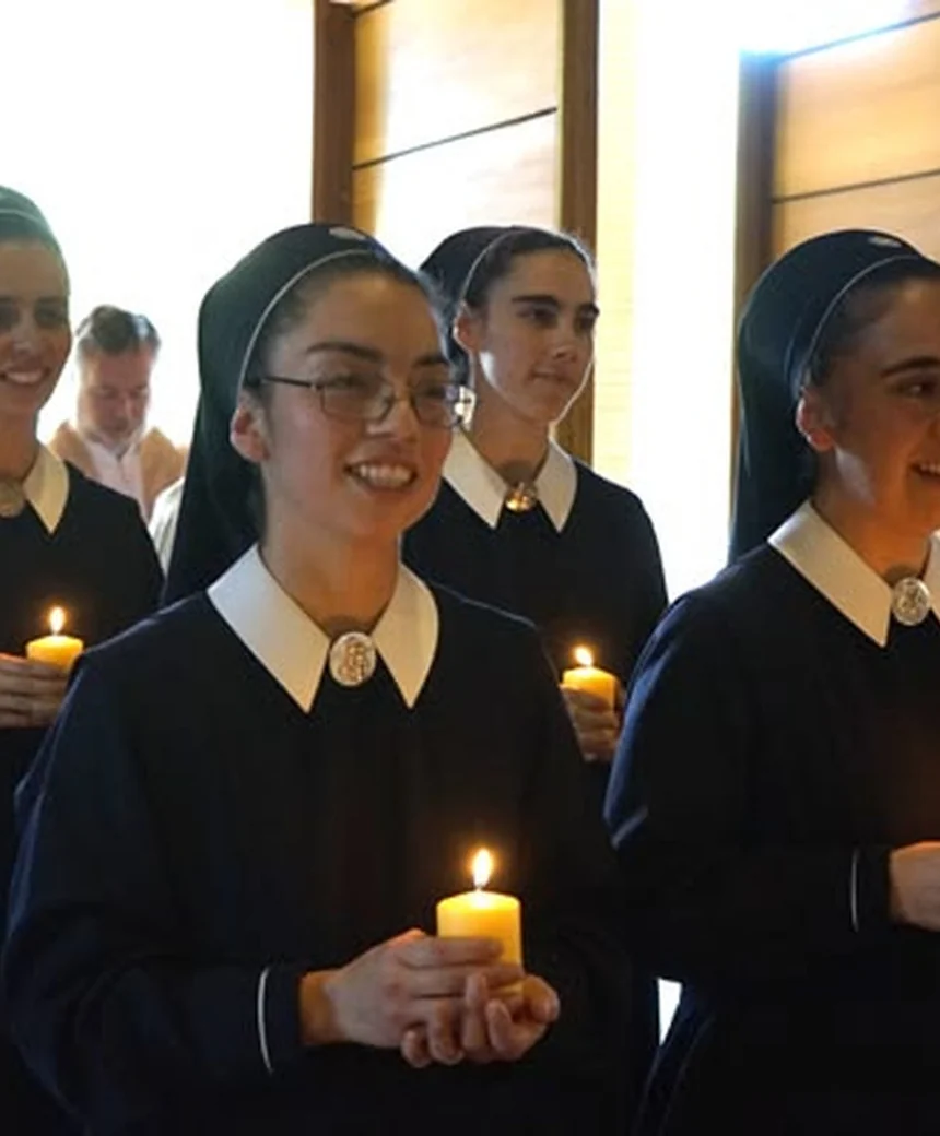Jóvenes Hermanas de María con velas en una celebración